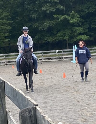 teenager on a horse with instructor